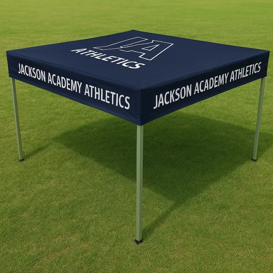 Custom navy blue canopy tent with Jackson Academy Athletics branding on a grass field.