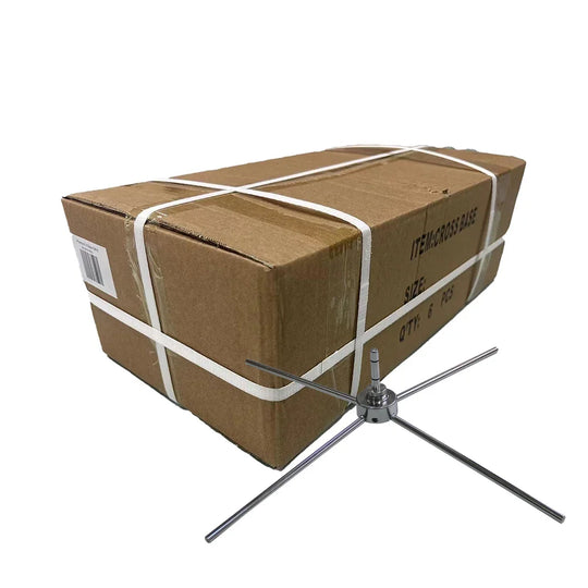 A metal cross base stand positioned next to a brown cardboard shipping box.