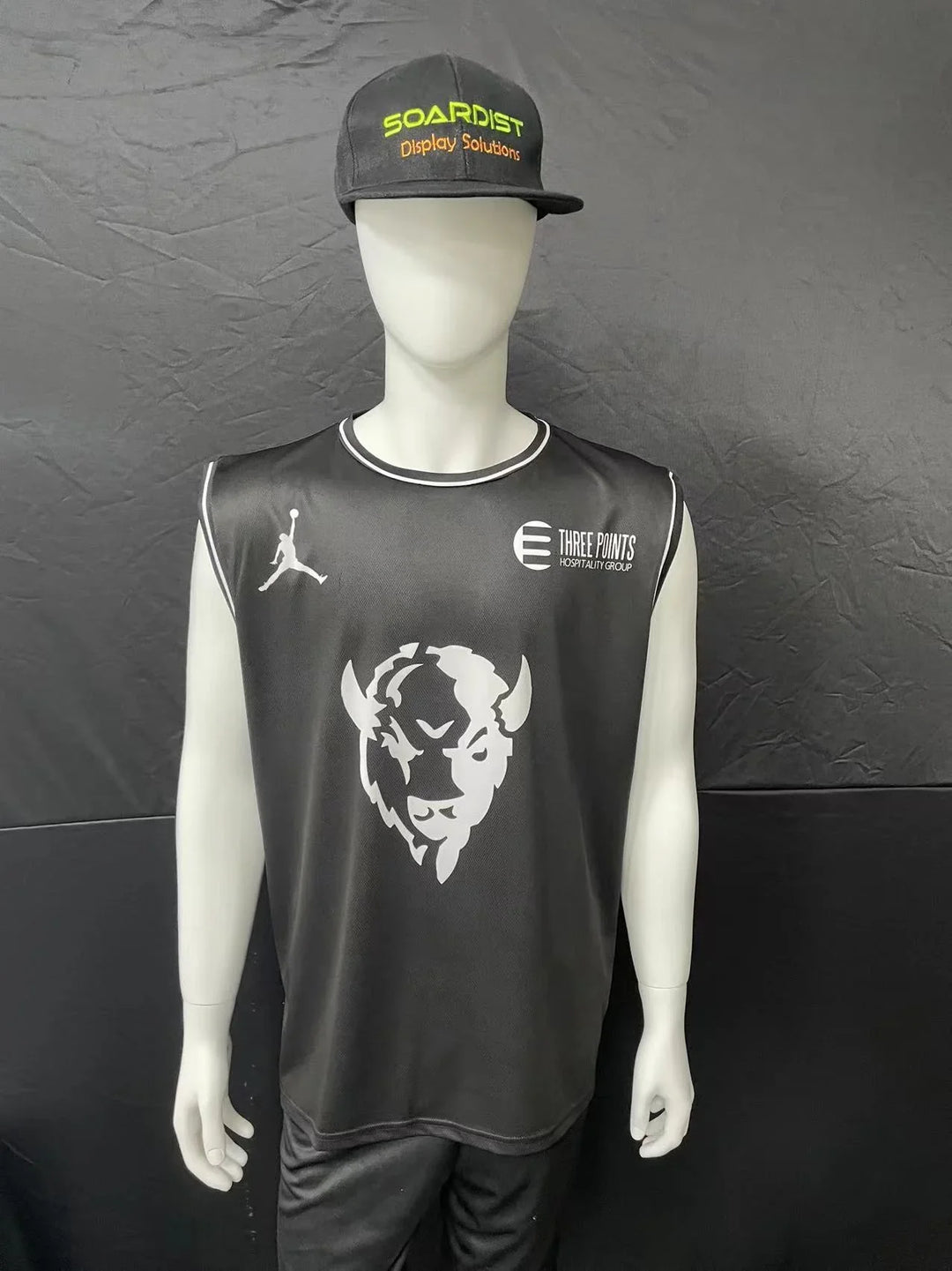 Mannequin wearing a custom black athletic jersey and matching baseball cap.