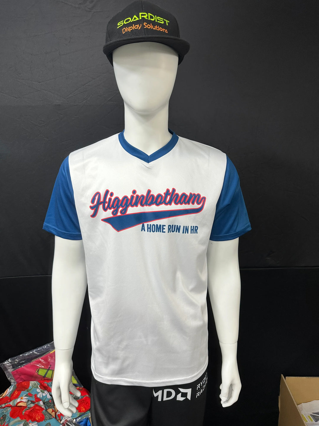 Custom white and blue baseball jersey with Higginbotham text on a mannequin
