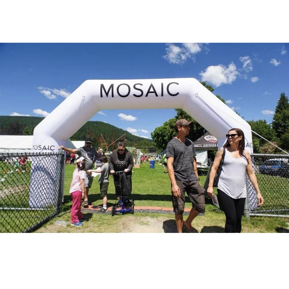 People walking under a white MOSAIC branded inflatable archway at an outdoor event.
