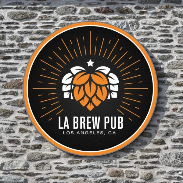 Round custom business sign for LA Brew Pub mounted on a stone wall