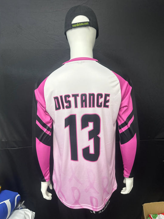 Back view of a custom pink and white long sleeve athletic jersey with 'DISTANCE 13' printed on it.