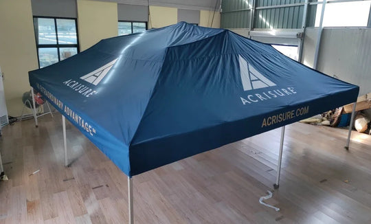 Custom blue Acrisure branded pop-up canopy tent indoors