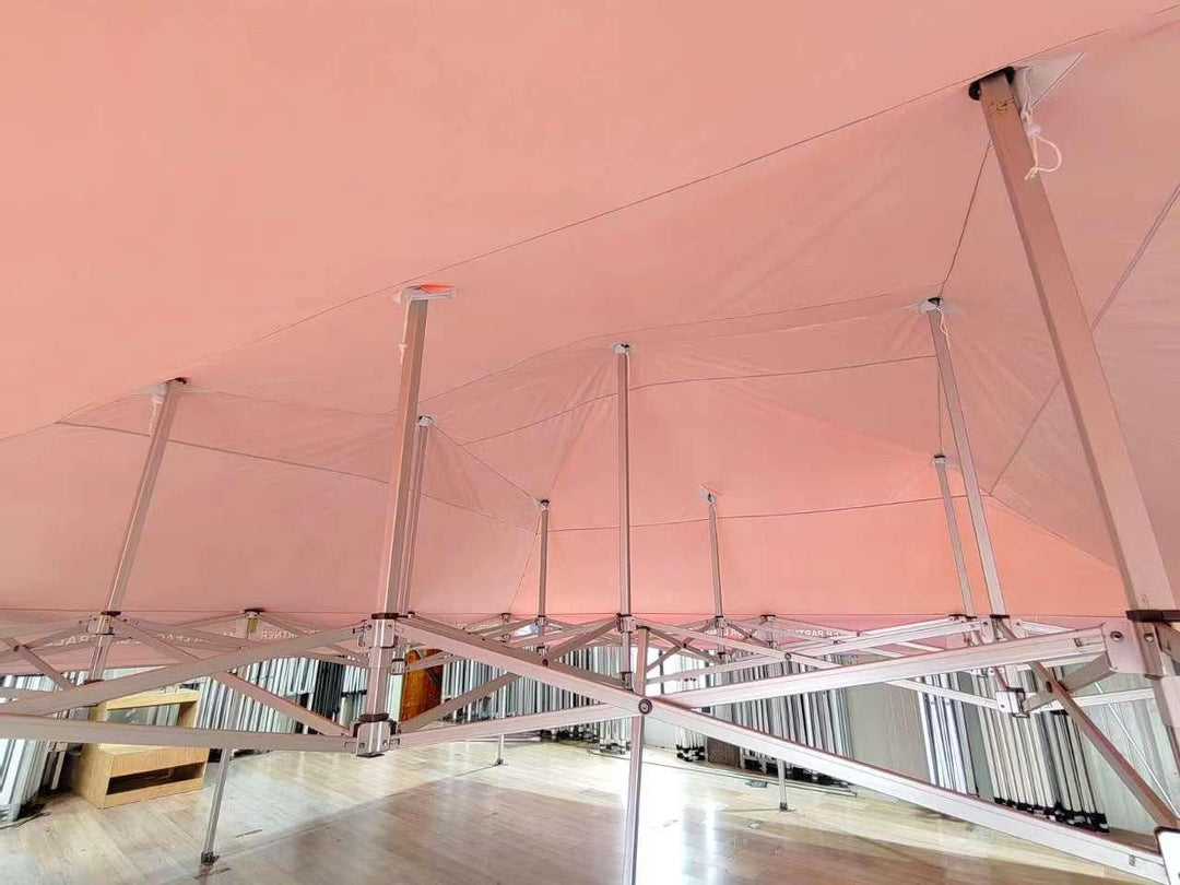 Interior view of a large pink custom event tent with a silver metal frame structure