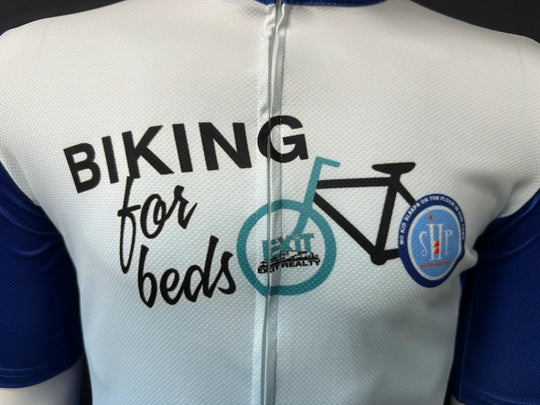 Close-up of a white custom cycling jersey with 'Biking for Beds' text and bicycle graphic.