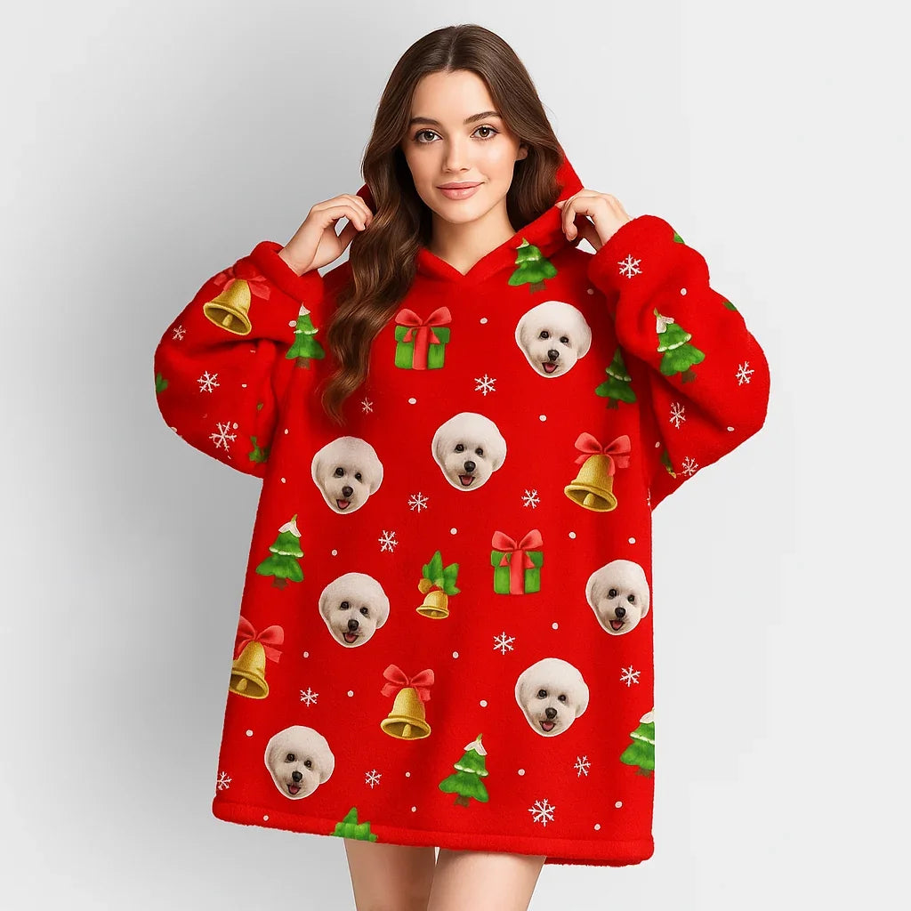 Woman wearing a red oversized hoodie with gold bells, Christmas trees, and white puppy prints.