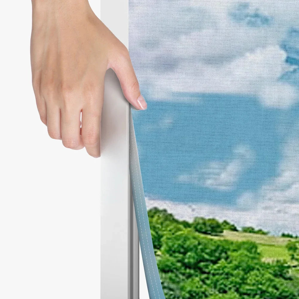 Close-up of a hand adjusting a custom printed fabric banner with a landscape image.