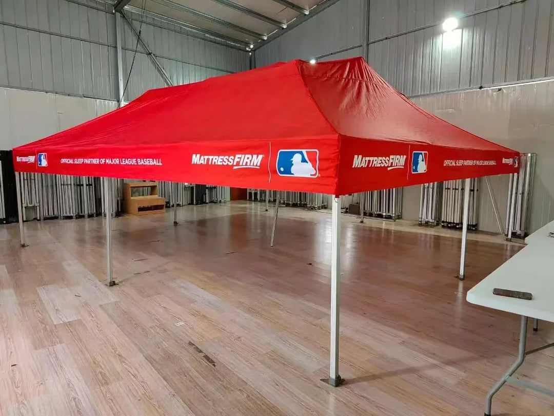 Custom red Mattress Firm promotional pop-up tent in a warehouse setting