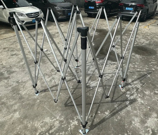 Folded aluminum frame of a custom pop-up canopy tent on a concrete surface