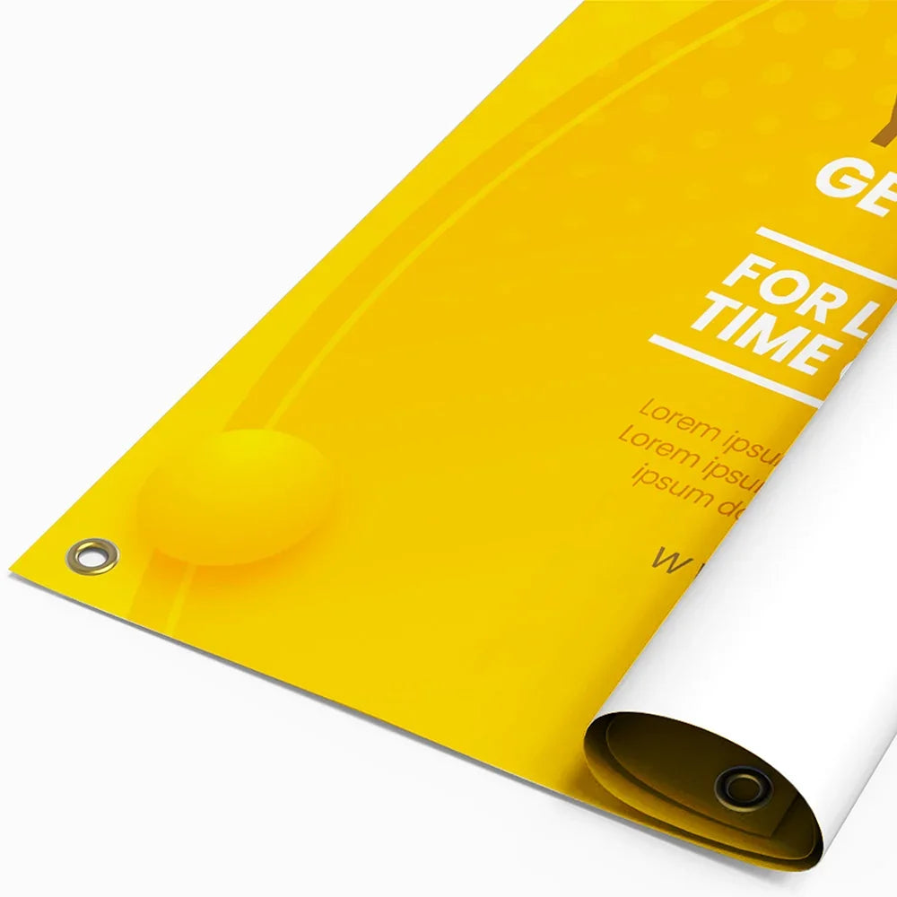 Close-up of a yellow custom vinyl banner with white text and metal grommets
