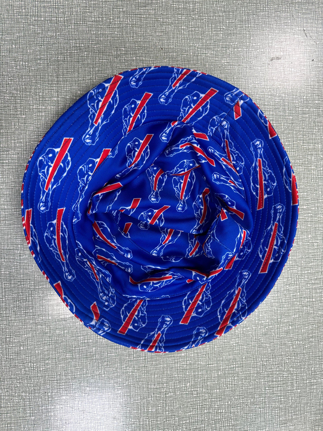 Blue bucket hat with a repeated red and white graphic pattern