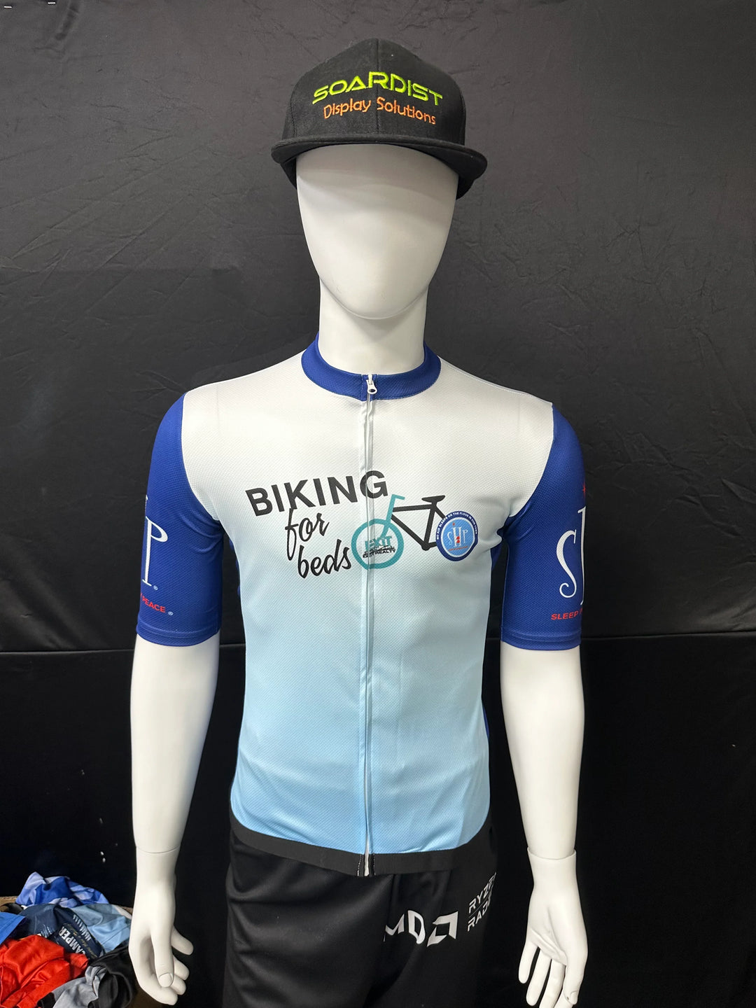 Custom cycling jersey and hat on a mannequin for Biking for Beds.