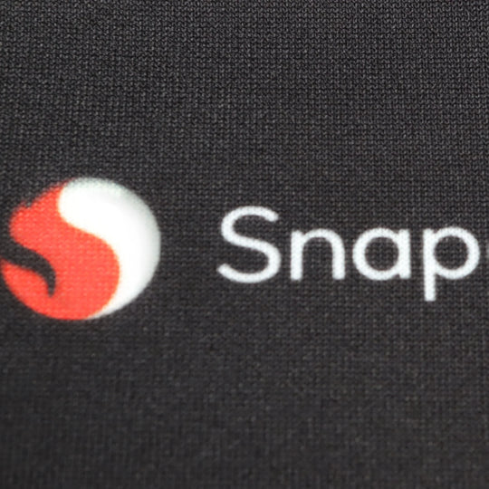 Close-up of a Snap logo printed on black custom apparel fabric.