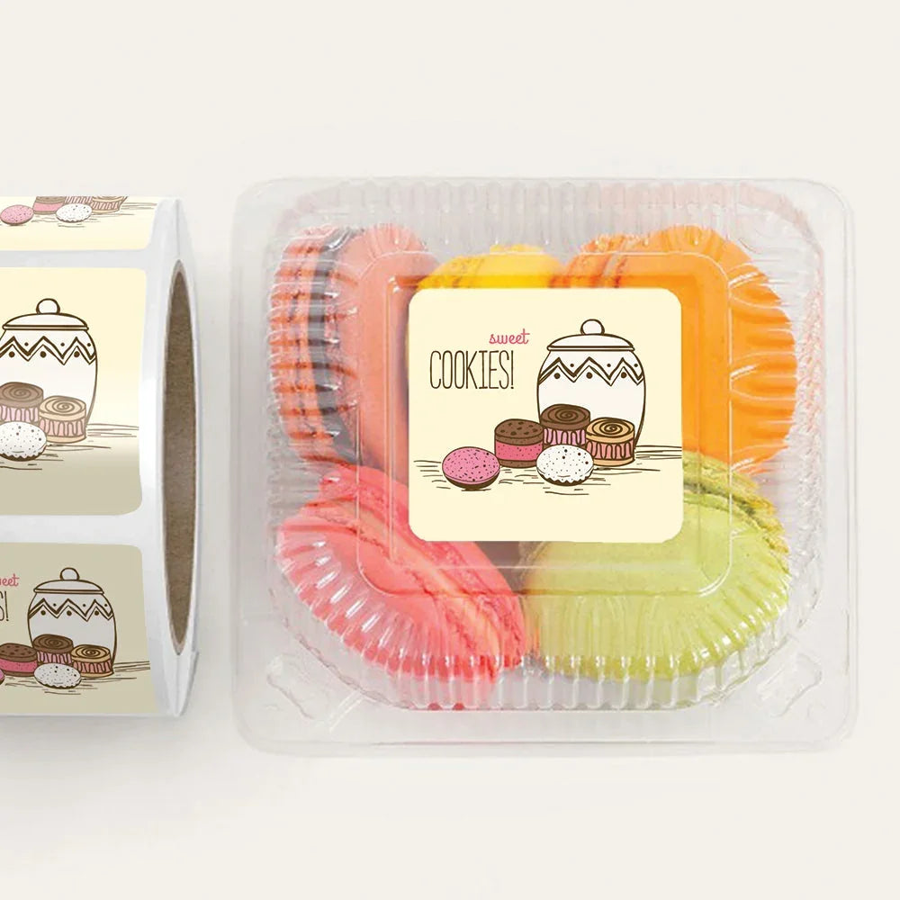 Custom 'Sweet Cookies!' labels on a roll and applied to a container of colorful macarons.