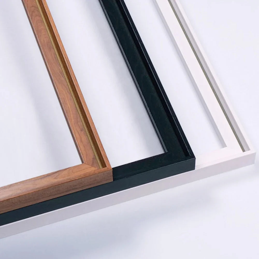 Three slim picture frames in wood, black, and white finishes.