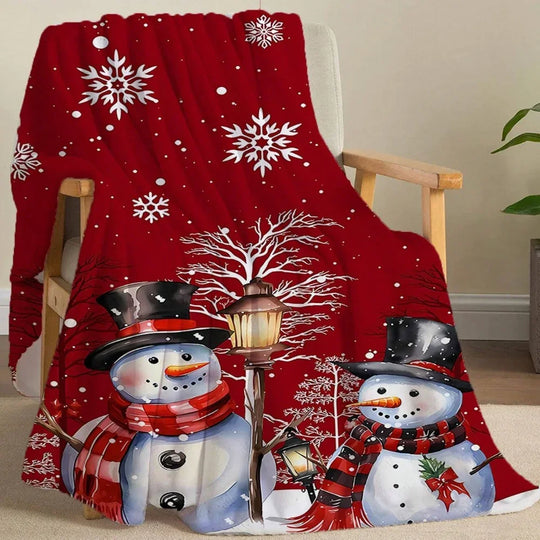 Red Christmas fleece blanket featuring two snowmen and white snowflakes