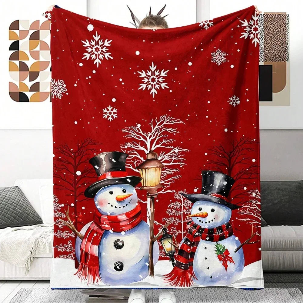 Red winter blanket featuring two snowmen with scarves and hats under snowflakes