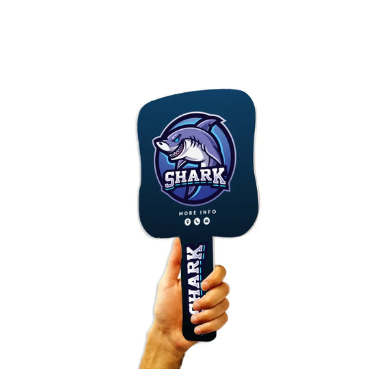 Hand holding a custom navy blue paddle with a shark logo and text.