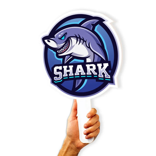 Hand holding a circular custom handheld sign featuring a shark mascot logo