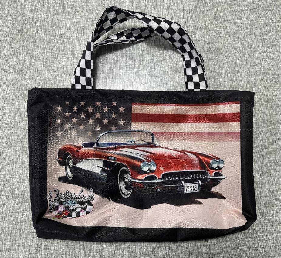 Black tote bag featuring a red classic Corvette with a US flag background and Texas plate.