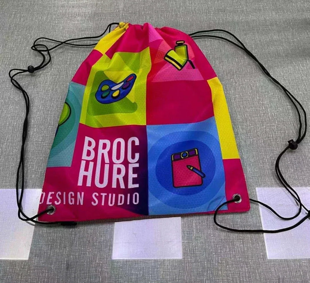 Colorful custom drawstring bag with Broc Hure Design Studio branding and art icons.